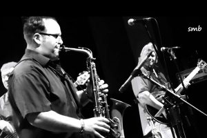 Black and white photo of Chris Beebe Aldridge playing sax with Climax Blues Band